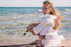 年轻的金发女郎女孩白色衬衫沉思的坐在海滩埃及异国情调的美高决议故障古董破旧的珊瑚绿松石效果