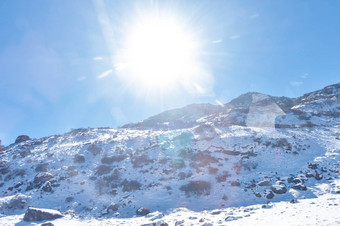 太阳前雪封面喜马拉雅山脉范围冻岩石峰填满深雪照亮不断上升的阳光<strong>冷</strong>淡的冬天一天时间蓝色的清晰的天空云路径太阳风景如画的自然美