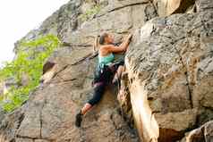 美丽的女人攀爬岩石山冒险极端的体育运动概念