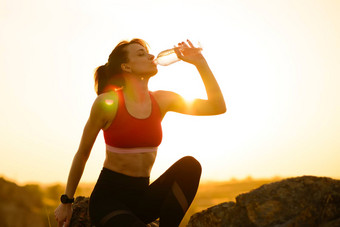 女人休息喝水运行户外锻炼热夏天日落体育运动健康的活跃的生命系统
