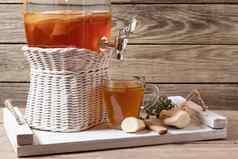 新鲜的自制的红茶菌发酵茶喝Jar水龙头杯白色托盘木背景Copyspace