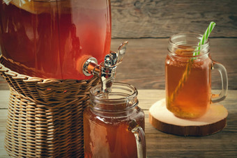 新鲜的自制的红茶菌发酵茶喝Jar水龙头cans-mugs木背景