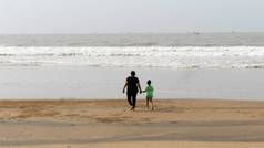 后视图妈妈。儿子走热带海滩晚上日落孩子欣赏妈妈信仰快乐母亲的一天背景概念果阿印度南亚洲太平洋夏天