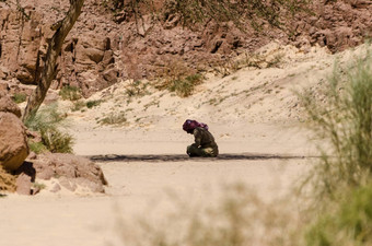 贝都因人祈祷坐着沙子阴影树