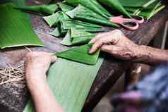祖母手工作香蕉叶使花容器人使传统的项当地的仪式参与