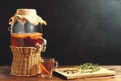 新鲜的自制的红茶菌发酵茶喝Jar水龙头杯黑暗背景