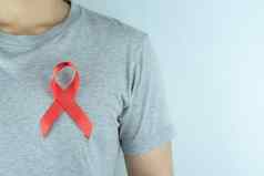 艾滋病意识红色的丝带男人。胸部世界艾滋病一天hea