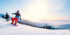 年轻的滑雪骑红色的滑雪板山阳光明媚的一天滑雪冬天体育