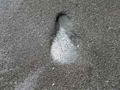 足迹跟踪湿灰色沙子海滩泡沫