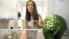 女人冰箱智能手机使列表食物