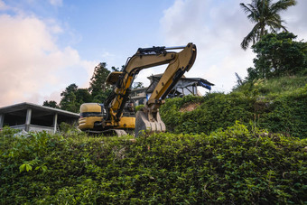 现代挖掘机建设网站日落天空大跟踪挖掘机站山绿色草机械建设建筑农村