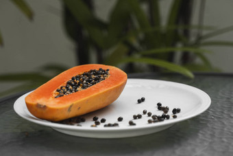 一半成熟的木瓜种子白色盘子绿色植物背景片甜蜜的木瓜减少了一半木瓜健康的异国情调的水果素食者食物