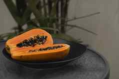 一半成熟的木瓜种子黑色的盘子绿色植物背景片甜蜜的木瓜减少了一半木瓜健康的异国情调的水果素食者食物