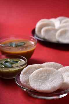 伊德利水鹿椰子酸辣酱红色的背景印度菜南印度最喜欢的食物拉瓦伊德利粗粒小麦粉悠闲地拉瓦悠闲地服务水鹿绿色酸辣酱