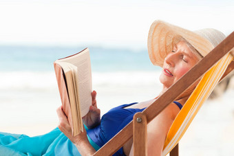 上了年纪的女人阅读书海滩