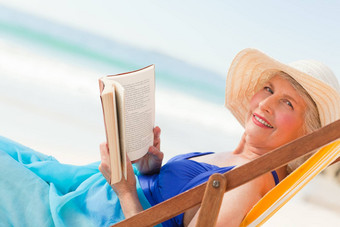 上了年纪的女人阅读书海滩