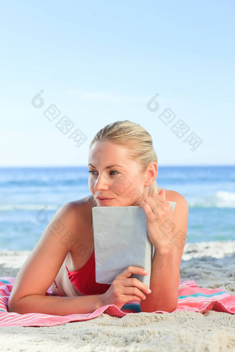 可爱的女人摆姿势书海滩