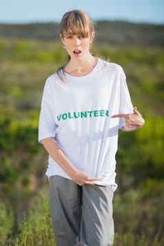 自然年轻的金发女郎指出志愿服务衬衫