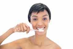迷人的黑色的头发的女人刷牙牙齿