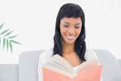 深思熟虑的黑色的头发的女人白色衣服阅读书