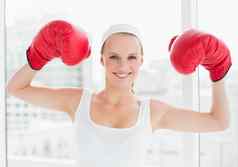 成功的漂亮的女运动员提高拳击手套