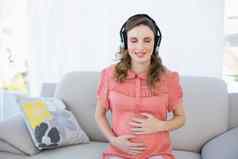 和平怀孕了女人放松听音乐坐着生活房间