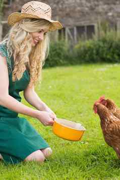 年轻的女人喂养鸡