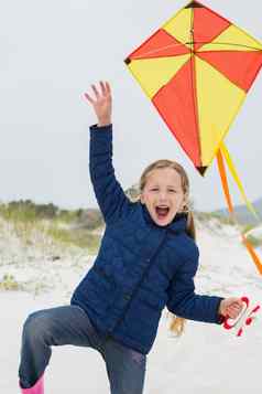 快乐的年轻的女孩风筝海滩