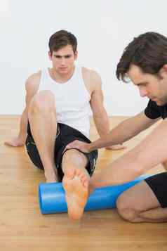 物理治疗师检查年轻的男人腿