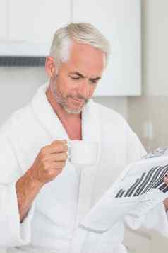快乐男人。阅读报纸早餐浴袍