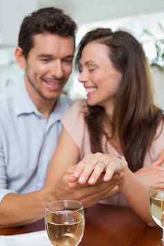 快乐女人显示订婚环男人。