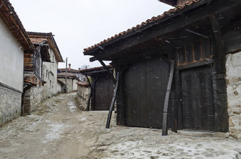 真实的独特的住宅区画明亮的颜色房子石头墙木窗户走廊风景如画的屋檐降雪Koprivshtitsa小镇