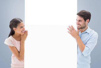 复合图像有吸引力的年轻的夫妇微笑持有海报