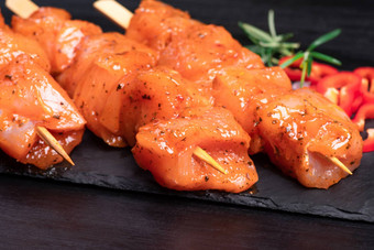 生腌制辣的鸡串生鸡串腌料香料黑色的板木表格前视图鸡肉关闭生肉腌料品尝饮食肉