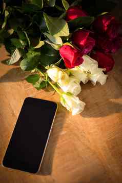 黄色的红色的玫瑰智能手机木表格