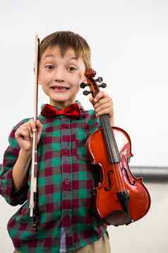 可爱的男孩持有小提琴弓教室