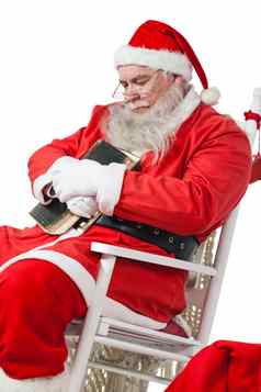 圣诞老人老人持有圣经放松椅子