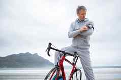 男人。自行车听音乐移动电话海滩