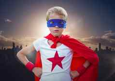 男孩超级英雄服装手腰站城市景观背景