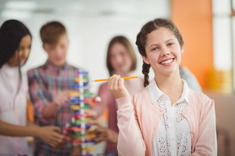 肖像微笑女学生持有铅笔教室