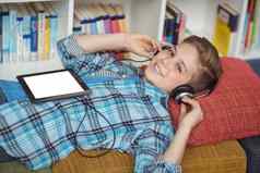 小学生放松沙发上听音乐数字平板电脑图书馆
