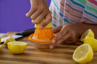 女人准备柠檬汁<strong>榨汁机</strong>紫罗兰色的背景