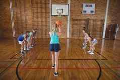 高学校女孩点球拍摄玩篮球