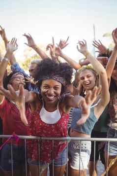 快乐的年轻的女人栏杆享受音乐节日