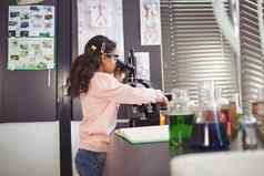 一边视图小学女学生显微镜实验室