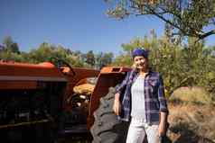 肖像自信女人站拖拉机橄榄农场