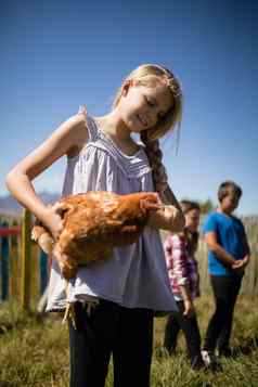 微笑女孩携带母鸡农场
