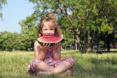 女孩坐着草吃西瓜
