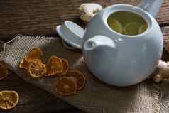 柠檬片茶壶姜干橙色木表格