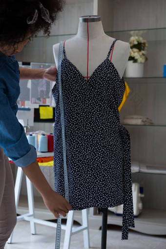 女设计师测量长度衣服人体模型